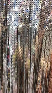 Makroaufnahme der Paillettenfransen in Silber und Gold mit schimmerndem Metallic-Glanz