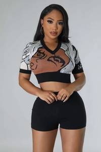 Detail of knit two-piece set featuring pop art face pattern on cropped top and shorts