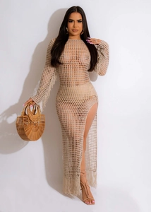 Detail of beige hollow crochet dress featuring mesh design and long fringe tassels