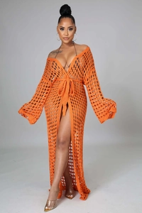 Detail of bright orange crochet cover-up showing intricate hollow-out knit and waist tie