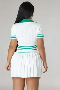 Rear view of knit two-piece sports set with green striped trim on white pleated skirt