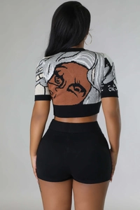 Detailed back view of knit crop top with anime portrait jacquard and black slim shorts