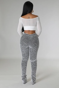 Macro view of high-waist flared pants featuring black and white textured stripes and fringes