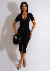 Détail de robe en maille côtelée noire avec col polo, boutons et fente latérale haute