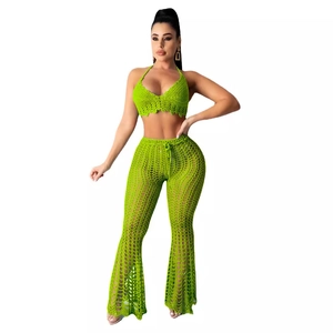 Bright green crochet two-piece set featuring halter crop top and flared pants for beach style