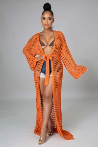 Detail of bright orange crochet long cardigan with hollow knit texture and waist tie
