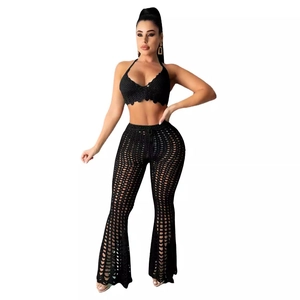 Women's black crochet two-piece set featuring a halter top and hollow-out flare pants