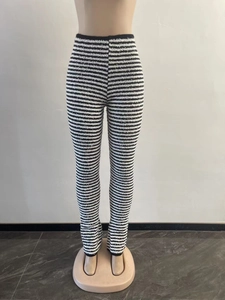 Detailed view of high-waisted black and white striped knit flare trousers on a mannequin