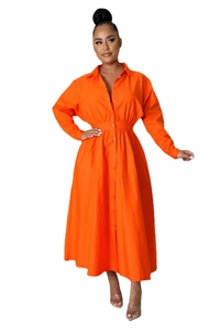 Détail d'une robe chemise orange vif avec taille élastique et boutonnage sur le devant