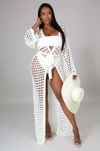 Detail of white crochet beach cover-up featuring open knit texture and tie waist design