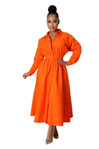 Détail d'une robe chemise orange avec fermeture à boutons et taille plissée