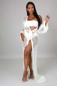Detail of white crochet knit cover-up showing geometric hollow patterns and waist tie