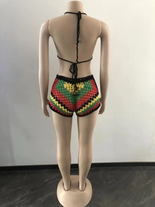 Detail of crochet knit beach shorts in red, yellow, and green stripes on female mannequin