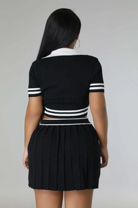 Rear view of knit two-piece set featuring short-sleeved top and pleated skirt with white stripes