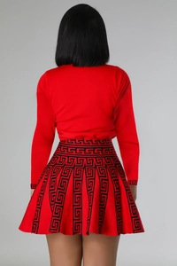 Rear view of red long sleeve pleated skirt set with black Greek key pattern trim