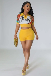 Detail of yellow knit two-piece set featuring a pop art portrait print on short polo top