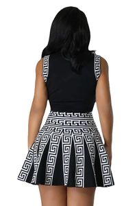Rear view of women's sleeveless black knit top and Greek key pattern pleated mini skirt