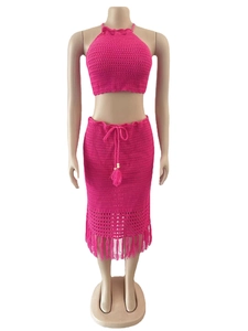 Détail d'un ensemble en crochet rose fuchsia avec haut licou et jupe à franges longues
