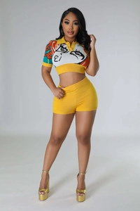 Detail of yellow knit two-piece set featuring artistic face illustration and polo collar