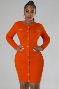 Detail of orange knitted dress featuring decorative metal chains and ribbed texture