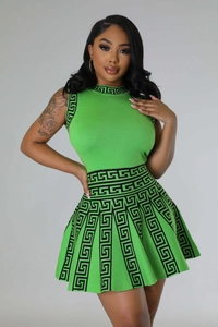 Close-up of green knitted sleeveless top and pleated skirt with black geometric Greek patterns