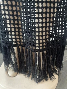 Close-up of black crochet hollow out knit cover up dress with long tassel hem details