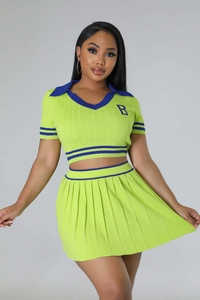 Detail of lime green knit polo top with navy stripes and pleated mini skirt set