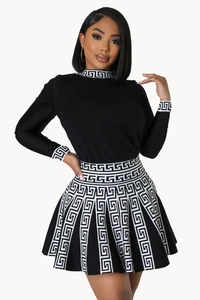 Detail of knit pleated skirt and cuffs featuring white Greek meander pattern motifs