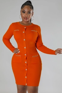 Detail of slim-fit orange knit dress featuring gold buttons and chain-trimmed pockets