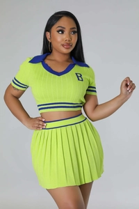 Detail of the knit texture and blue trim on the neon green two-piece pleated skirt set