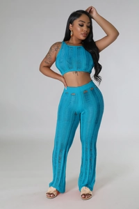 Detailed close-up of blue knitted two-piece set with distressed cut-outs and rib texture