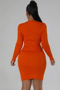 Detail view of the orange ribbed knit fabric and bodycon fit on long sleeve dress