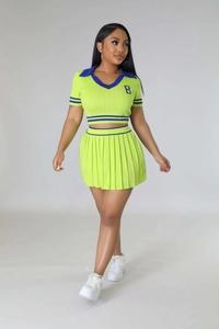 Detail view of knitted two-piece set featuring crop polo top and pleated skirt with contrast stripes