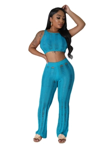 Detail of blue knitted two-piece set featuring ripped cutout texture and flared pants