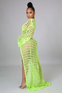 Detail of neon green crochet beach cover-up showing intricate hollow knit and side slit