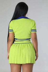 Back view of neon green knitted two-piece set featuring short sleeves and pleated skirt