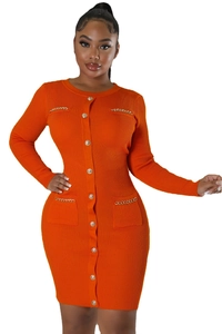 Detail of orange knitted dress featuring vertical ribs, gold buttons, and chain pockets