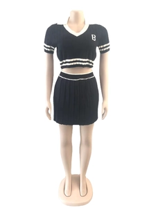Detail of knit sports set with white stripes on collar and pleated high-waist skirt