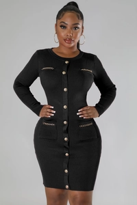 Detail of black knit dress featuring vertical ribbing and decorative gold chain accents