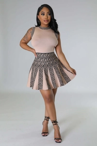 Detail of knitted sleeveless top and pleated skirt with Greek key pattern border