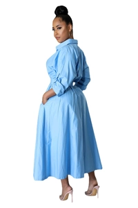 Détail d'une robe chemise bleu ciel à manches longues avec taille haute et coupe évasée