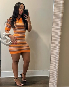 Detail of orange striped knit mini dress with polo neck and ribbed cuffs