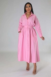 Détail d'une robe chemise rose à manches longues avec taille élastique et jupe trapèze élégante