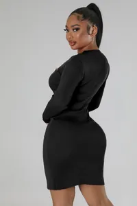 Detail of black ribbed knit mini dress with gold button accents and slim fit silhouette