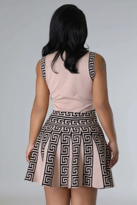 Detail of knitted pleated dress showing black Greek Key pattern on pink fabric back