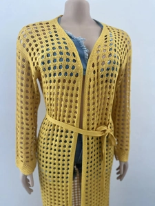Detail of ginger yellow openwork knit cardigan with long sleeves and matching waist tie