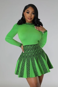 Detailed view of the green knit dress featuring black Greek meander patterns on cuffs