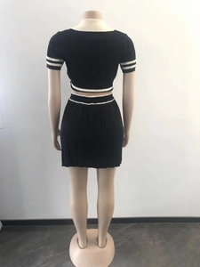 Detail of the back view of a black knitted set with white contrast stripes on a mannequin