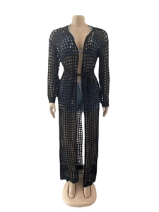 Detail of black crochet knit cover-up dress featuring hollow-out mesh and waist tie
