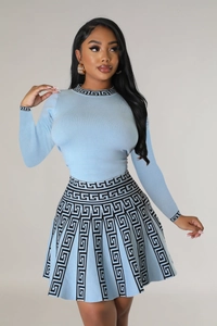 Detail of light blue knit set featuring Greek key patterns on collar and cuffs